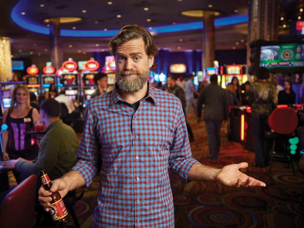 一个男人站在赌场的老虎机和桌上游戏前