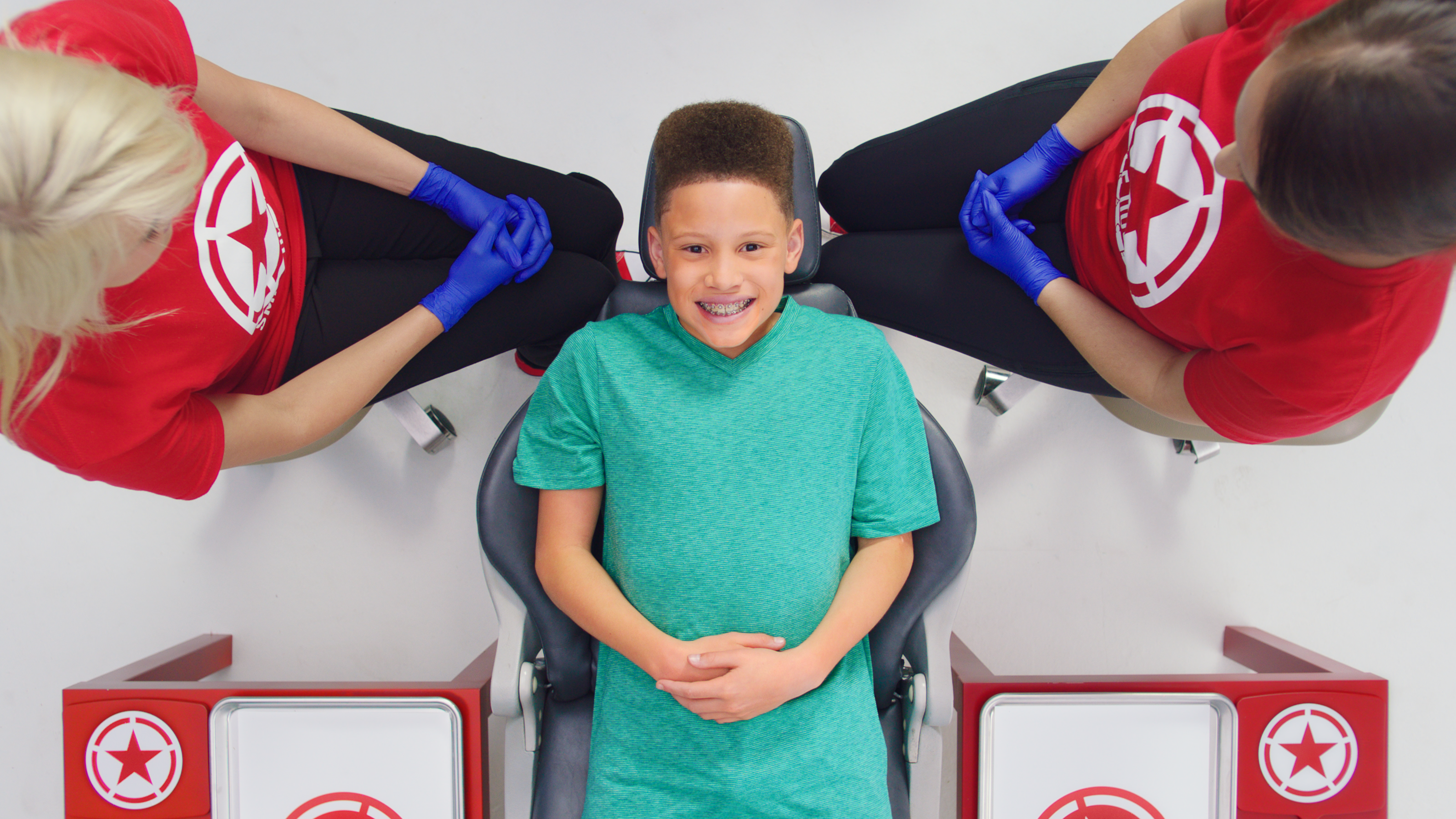 一个小男孩坐在牙医的椅子上微笑