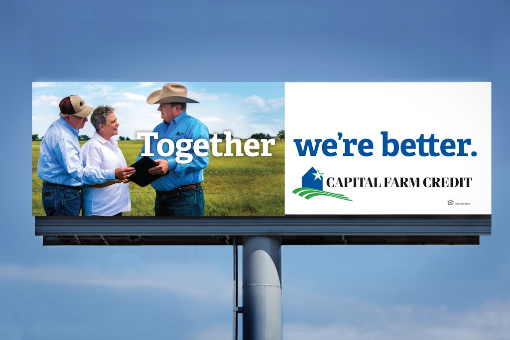 资本农场信贷的广告牌上有三个男人在田里