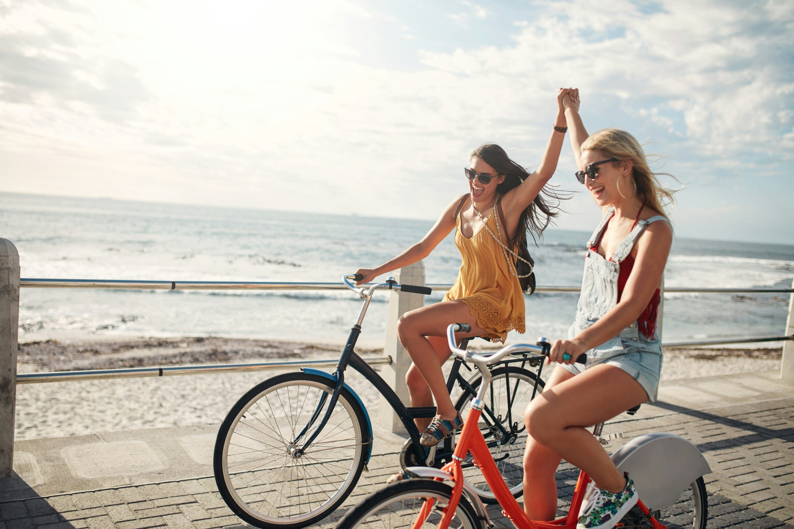 两个女孩在海滩上骑自行车