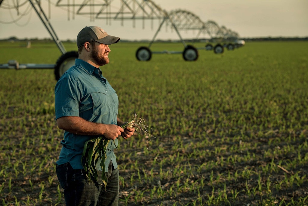 Farmer in field with irrigation equipment